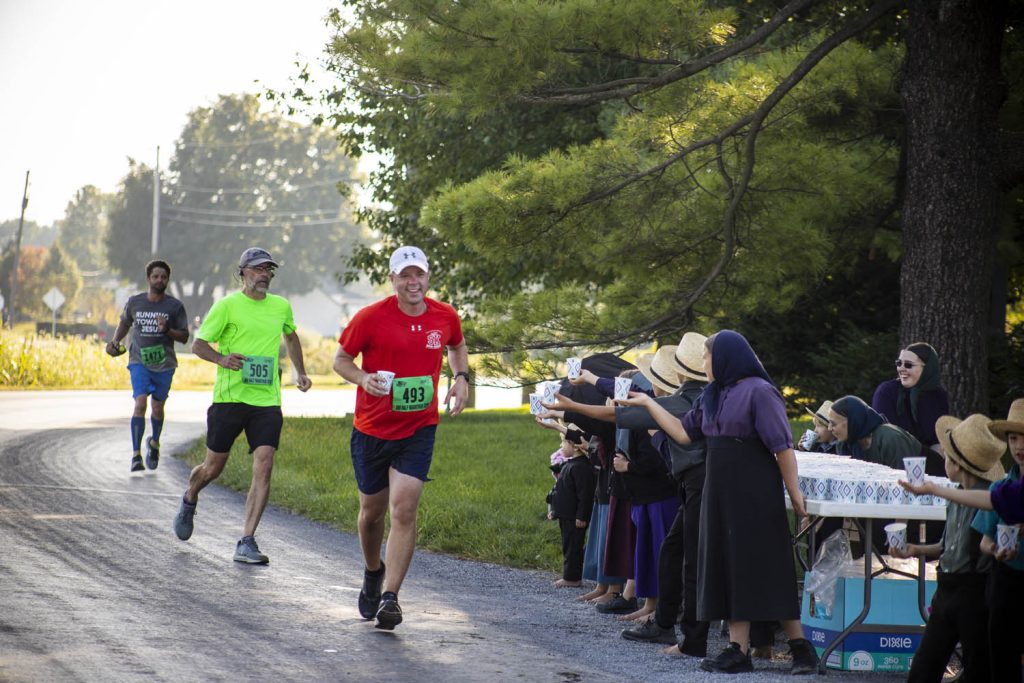 Volunteers offer water to runners at aid station